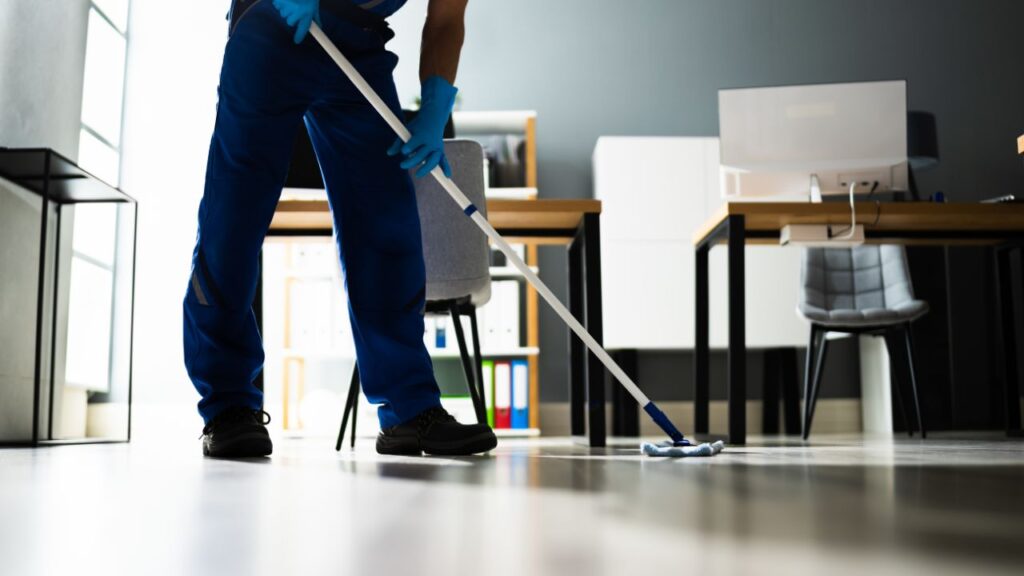 Professional janitorial staff in hospital attire, diligently cleaning a hospital corridor to ensure a safe and sanitary environment.