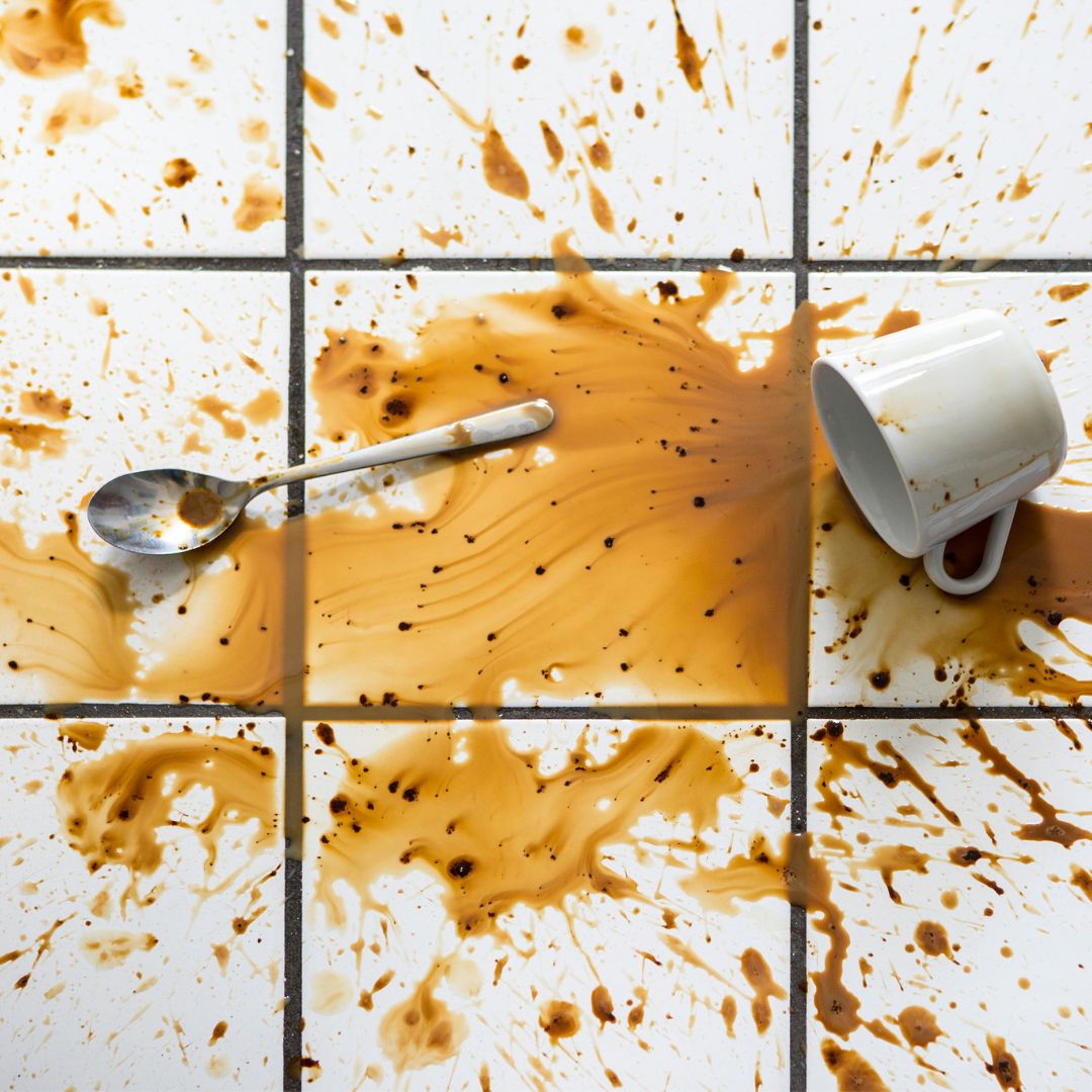 A high-traffic area kitchen floor is covered in spilled coffee.